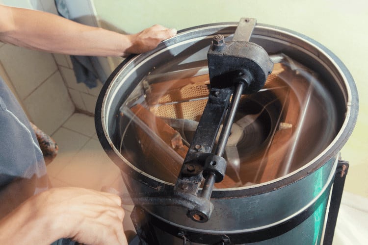 A beekeeper using a honey extractor