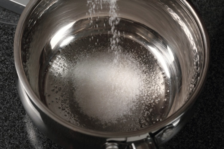 Pouring Sugar into Water Dipper to Make Water Syrup 