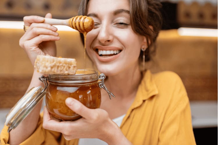 Woman eating honey at home